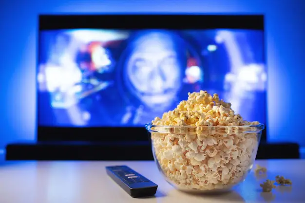 Popcorn dan remote control di sofa